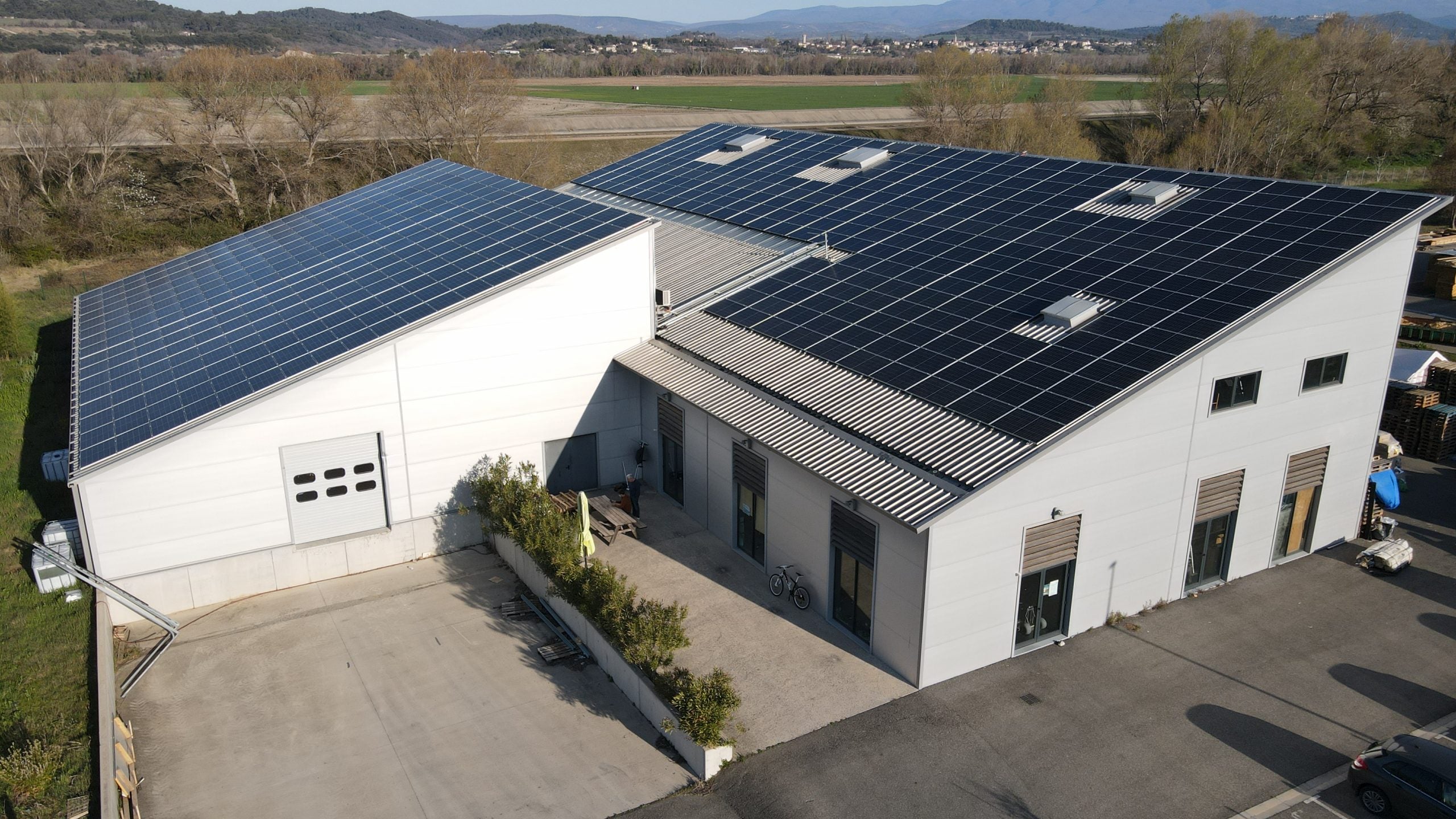 Image du bâtiment de la société, avec une installation électrique sue la totalité du toit