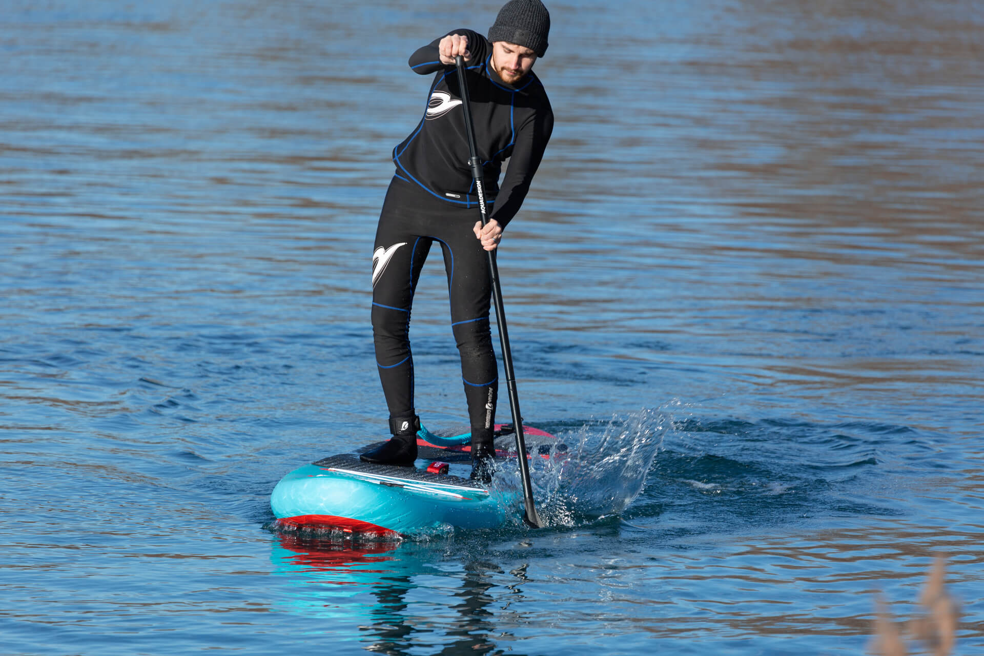 Photo en situation du Paddle SUP Fusion Kendo 10'6 zoom sur la prise de vitesse et de la pagaie dans l'eai. On remarque également le rocker de la planche
