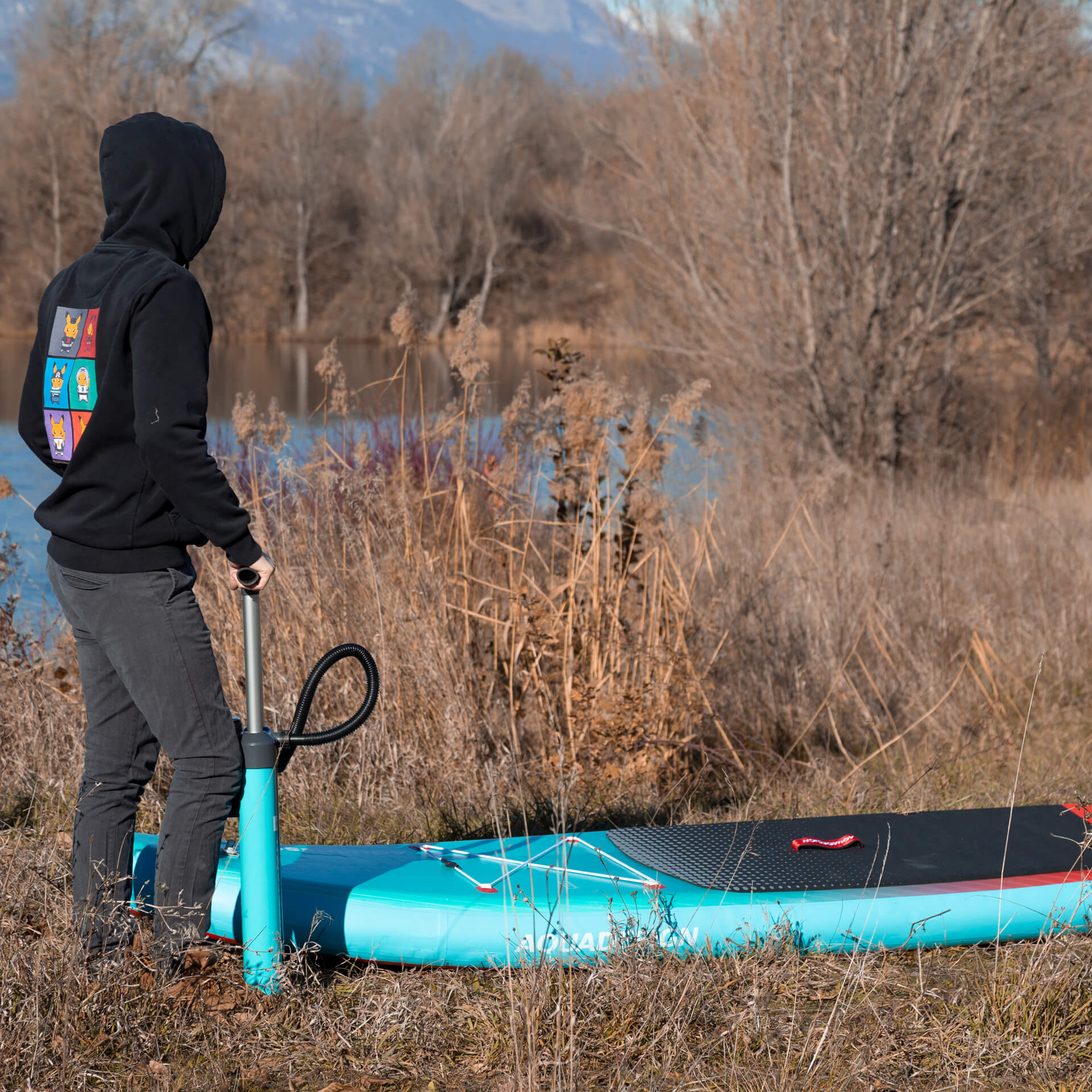 Photo en situation du Paddle SUP Fusion Kendo 10'6 Aquadesign, gonflage de la planche grâce à la pompe sup haute pression aquadesign