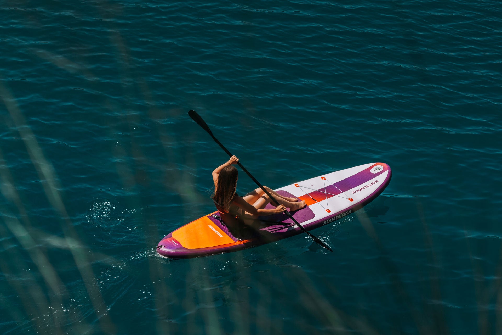 Photo de la planche de Stand up paddle Lava en mode Kayak, grace à un siege et une pagaie convertible inclus dans le pack