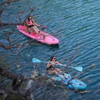 Deux femmes en kayak sur des SUP gonflables convertibles rose et bleu Aquadesign, vue aérienne depuis un arbre