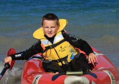 Gilet de sauvetage Enfant Aquadesign Piko pour le Kayak, Rafting, Paddle, Voile. Norme ISO 12402-4. En situation sur un garçon en K-AIR.